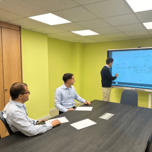 Code10 consultants participating in a technical knowledge-sharing session using an interactive digital whiteboard to discuss SAP integration architecture and enterprise solutions.