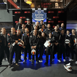 Code10 employees posing together before a karting team-building event in 2024, wearing racing suits and helmets.