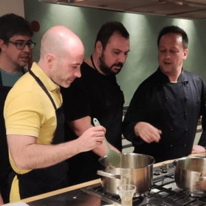 Code10 employees participating in a cooking workshop with a professional chef during a company team-building event.