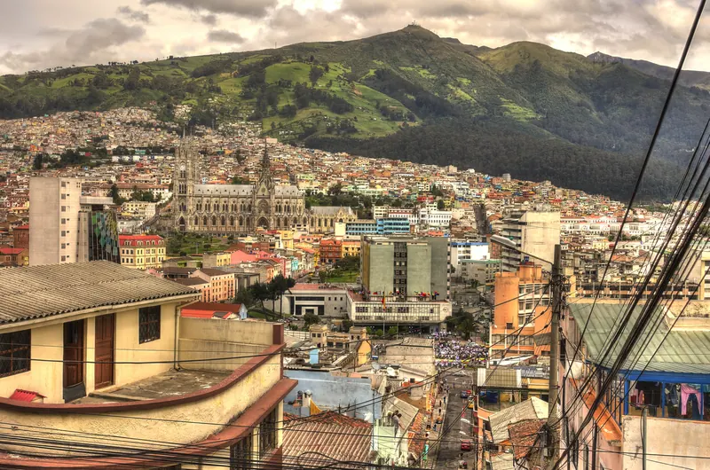 Vista de una calle de Quito con la Basílica y el Pichincha al fondo