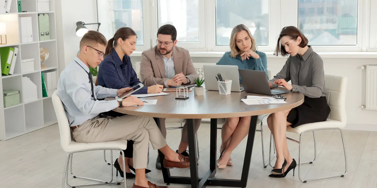 Profesionales colaborando alrededor de una mesa de reuniones