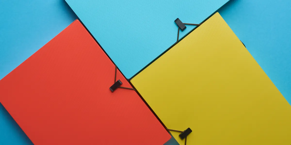 Carpetas de colores dispuestas sobre una superficie a juego