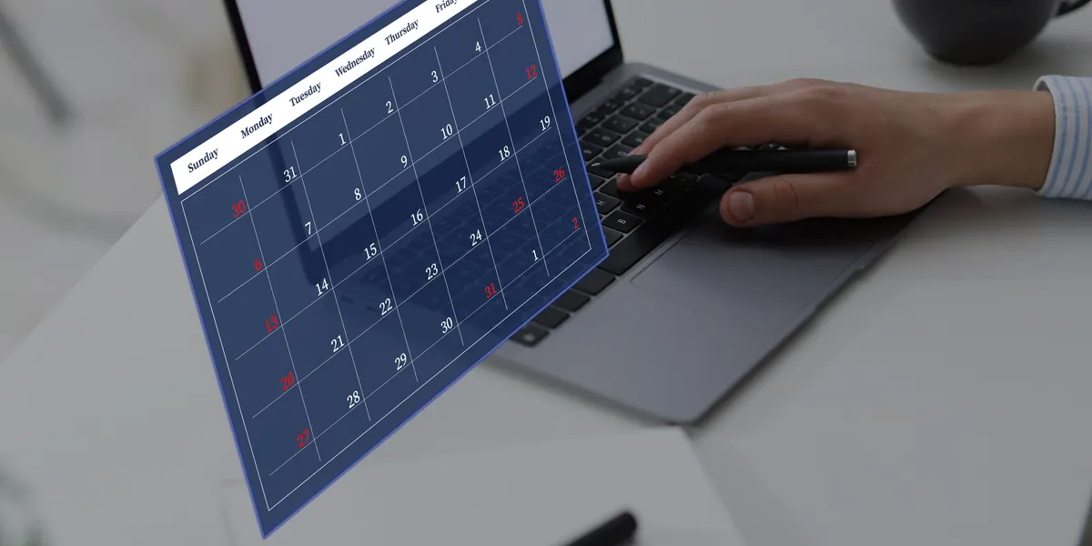 Mano utilizando un ordenador portátil con un calendario digital superpuesto