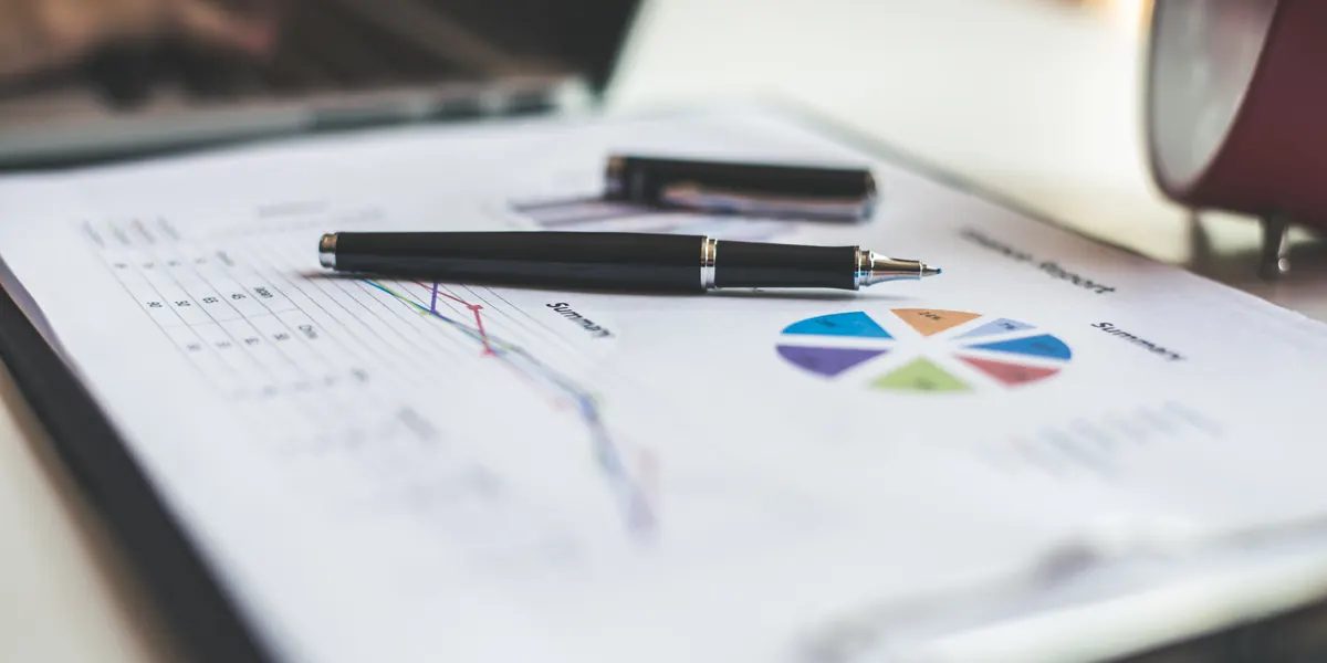 Informe financiero con gráficos y tablas, y un bolígrafo