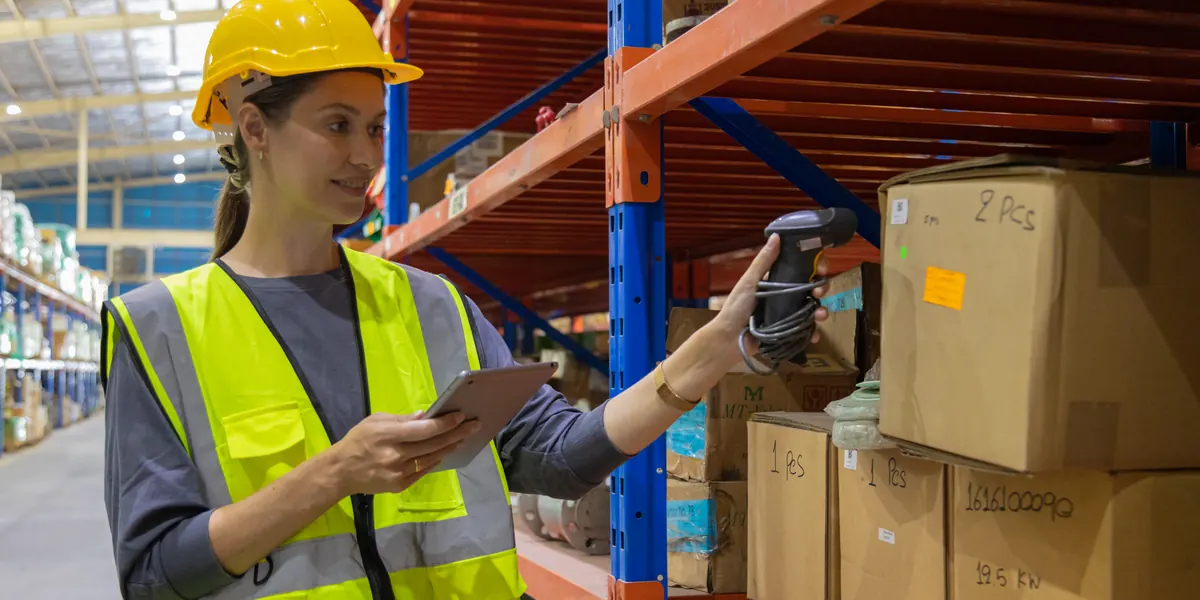 Empleado de almacén escaneando el inventario con una tableta y un escáner