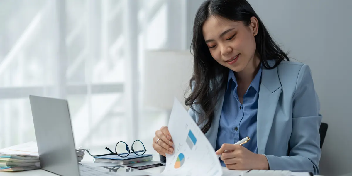 Una mujer revisando documentos financieros en una oficina luminosa