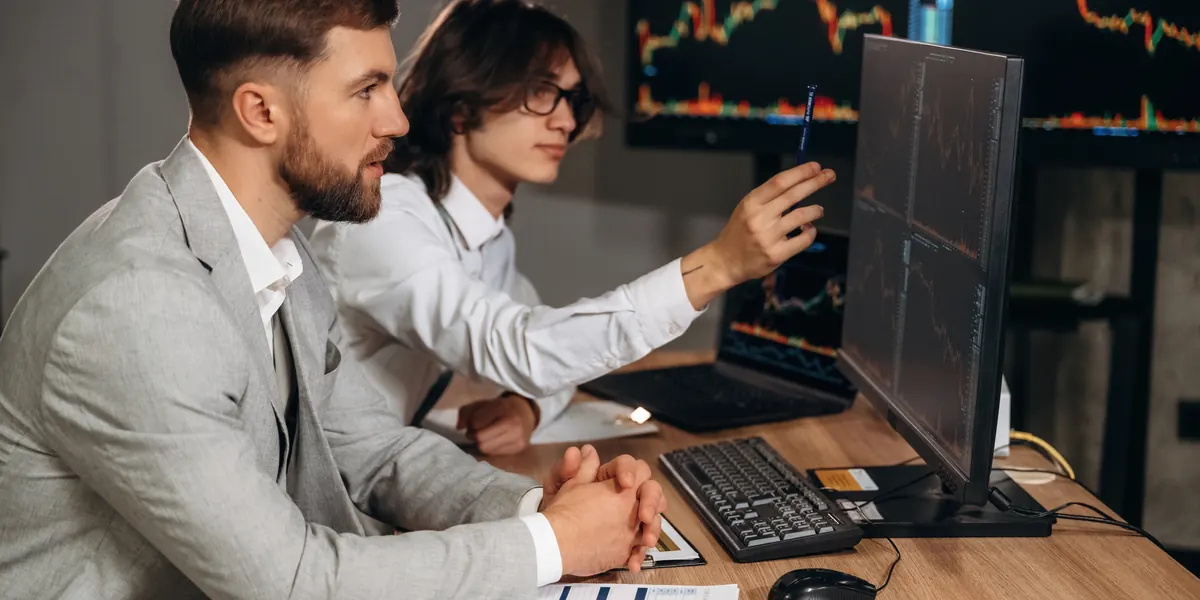El equipo de finanzas analiza datos financieros en dos pantallas