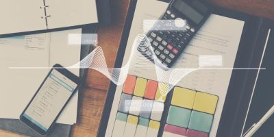 Financial documents, calculator and mobile device representing electronic tax reporting and digital financial compliance.