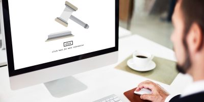 Professional accessing digital legal and regulatory compliance information on a desktop computer.