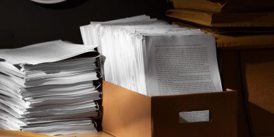 Archived business documents and paper records representing digital document archiving and regulatory compliance.
