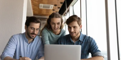 Business team collaborating on laptop to optimize automated processes
