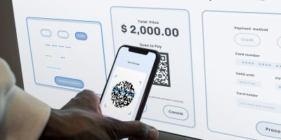 Business user scanning a QR code to complete a digital payment linked to electronic invoicing and tax compliance processes.