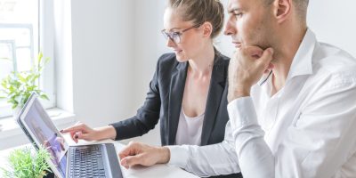 dos-empresarios-trabajando-en-la-computadora-portatil-en-el-lugar-de-trabajo