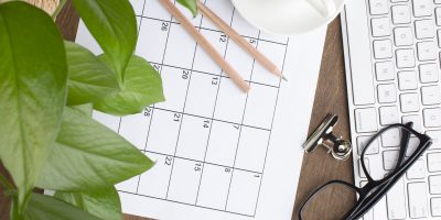 Business workspace with calendar, keyboard, and planning materials representing compliance deadlines and regulatory project management.