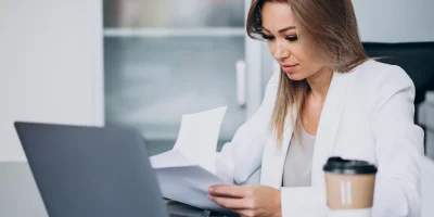 hermosa-mujer-de-negocios-trabajando-en-la-computadora-en-la-oficina-y-tomando-cafe
