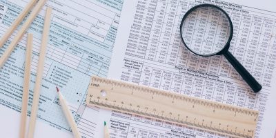 Financial documents with magnifying glass representing KSeF electronic invoicing and tax compliance in Poland