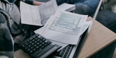 Invoices, calculator, and laptop representing TicketBAI tax compliance and financial management
