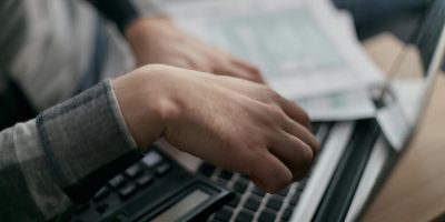 Professional using calculator and laptop representing SII VAT reporting and compliance regulations in Spain