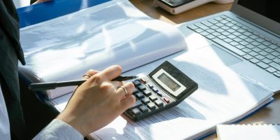 Accountant using calculator and pen representing SII VAT reporting and compliance regulations in Spain