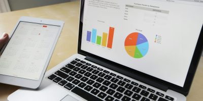 Portátil que muestra cuadros de mando de datos financieros y análisis relacionados con los informes SAF-T en Rumanía.