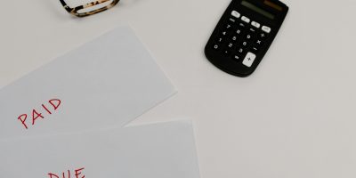 Calculator with paid and due documents representing TicketBAI tax compliance in the Basque Country