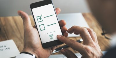 Professional reviewing a digital compliance checklist for FEC reporting and accounting audit preparation in France.