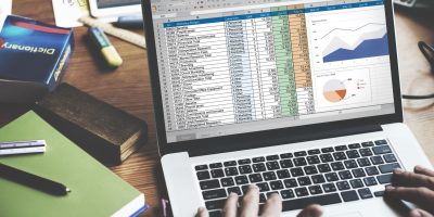 primer-plano-de-las-manos-usando-la-computadora-portatil-con-pantalla-que-muestra-datos-de-analisis