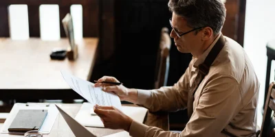 propietario-de-una-pequena-empresa-adulta-media-analizando-informes-mientras-trabaja-en-el-papeleo-en-un-pub