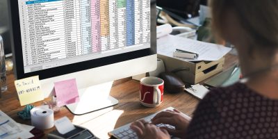 Professional reviewing financial spreadsheets and VAT reporting data for regulatory compliance in France.