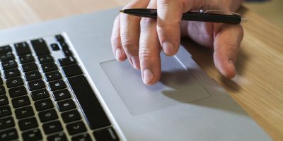 Professional working on a laptop to manage digital tax reporting and compliance processes in France.