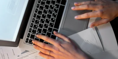 vista-superior-manos-escribiendo-en-el-teclado